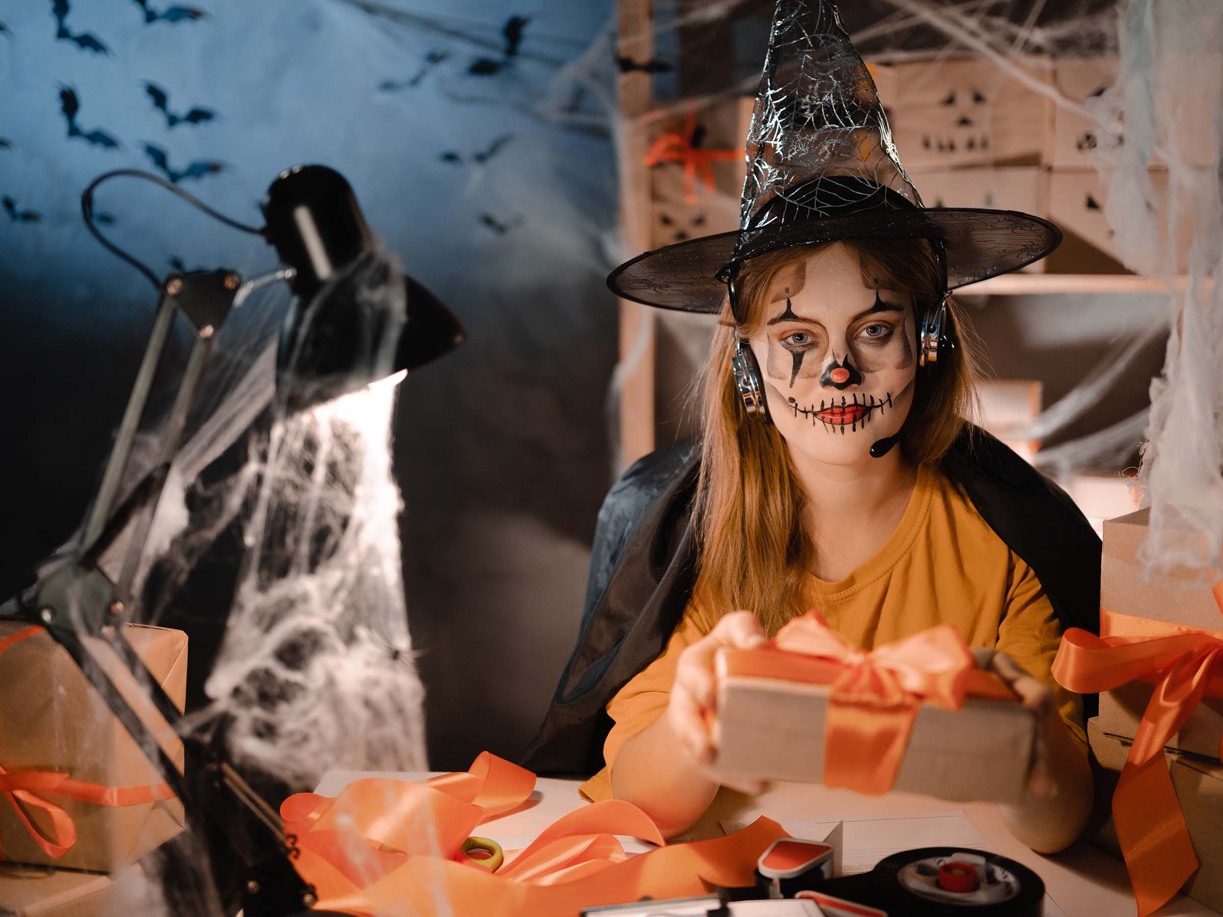 Décoration Halloween avec cadeaux et poste de travail illustrant la préparation des campagnes marketing avant le Black Friday et Noël